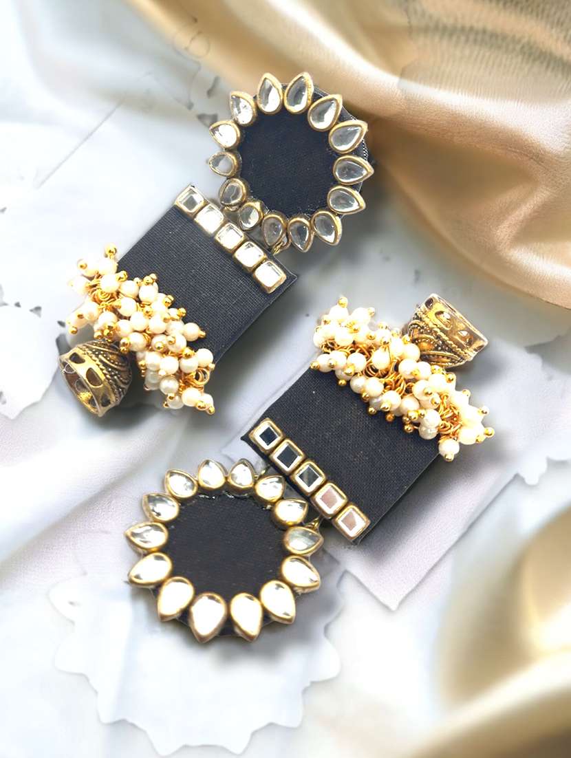 women's handmade fabric earring with kundan and tassels on wood