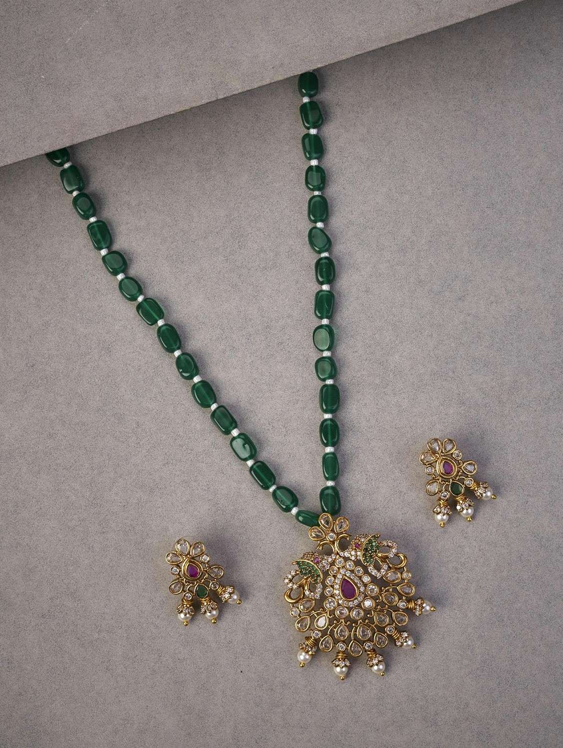 women stone studded pendent and earring set