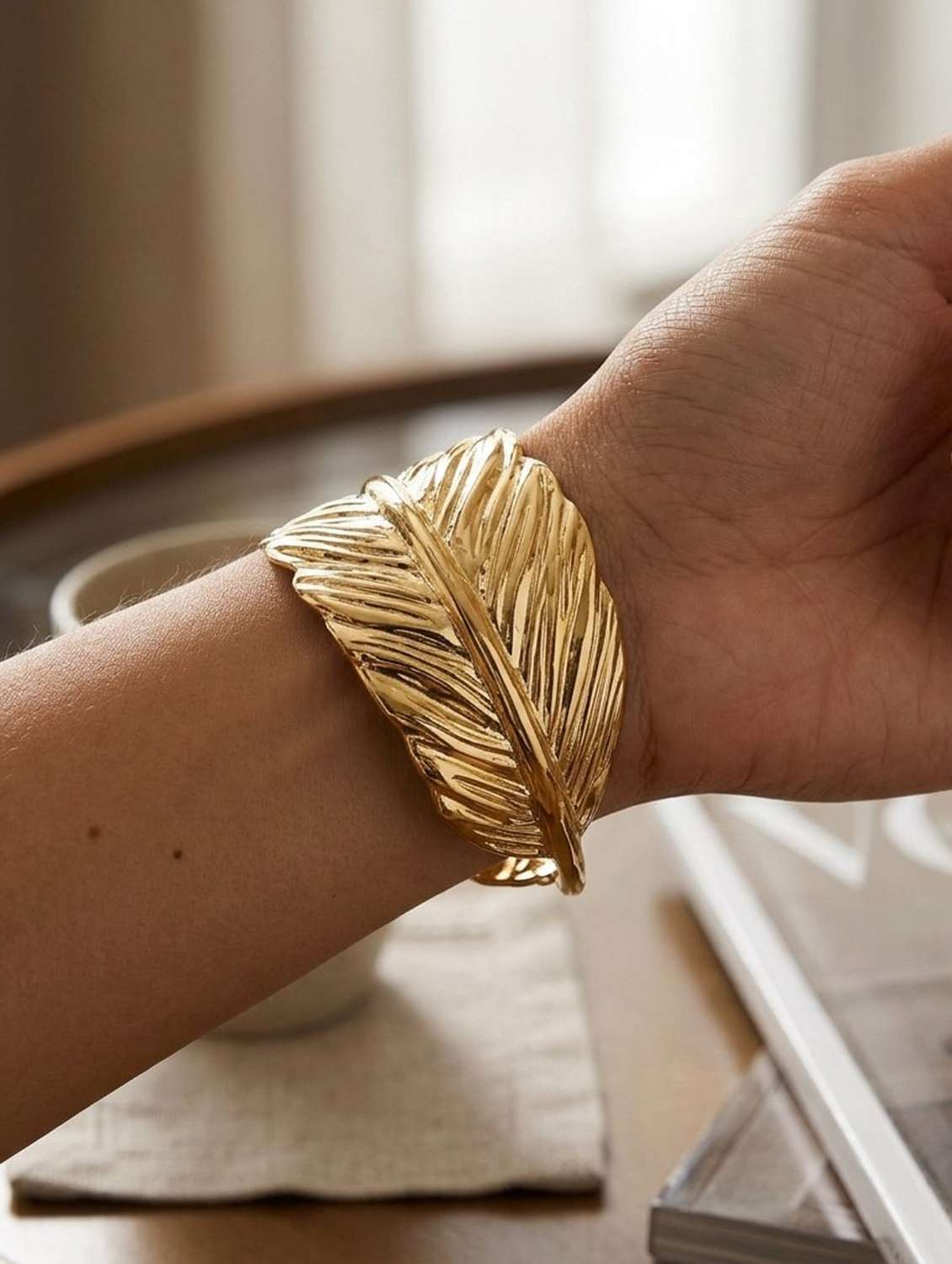 women gold textured leaf design bangle