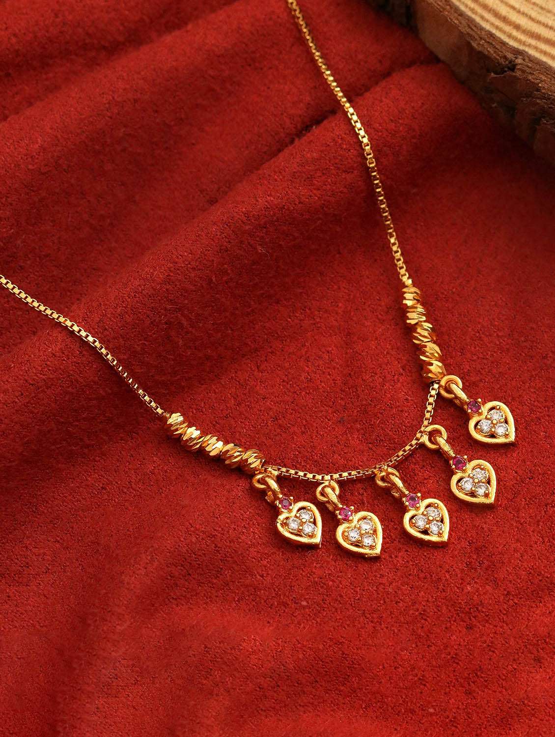 gold plated american diamond heart charm necklace with stone studded dangle charms